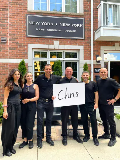 New York New York holding up a sign with a customer's name on it