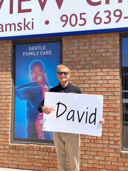 Dr. Andrew holding up a sign with a customer's name on it