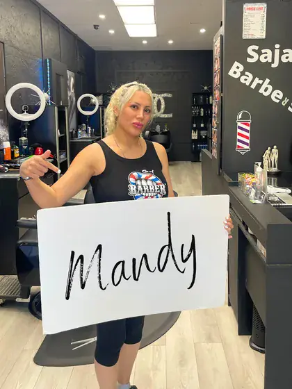 Saja holding up a sign with a customer's name on it